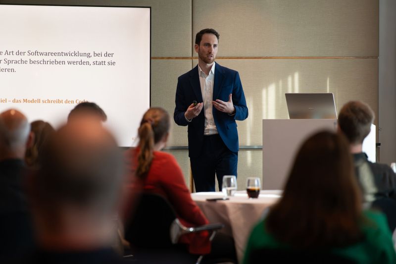 Aladin Ermel presenting to an audience at an AI and auditing event
